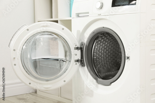 Modern washing machine in light laundry room