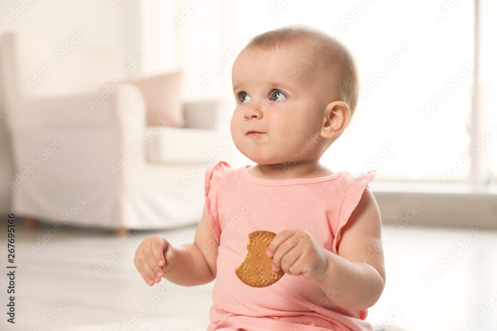 Portrait of cute baby girl with cookie in room Portrait of cute baby girl with cookie in room