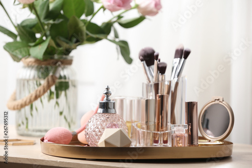 Tray with different makeup products and accessories on dressing table