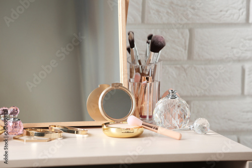 Different makeup products and accessories on dressing table