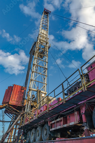Fotografie The design of the drilling rig for deep drilling in oil and gas against a blue sky