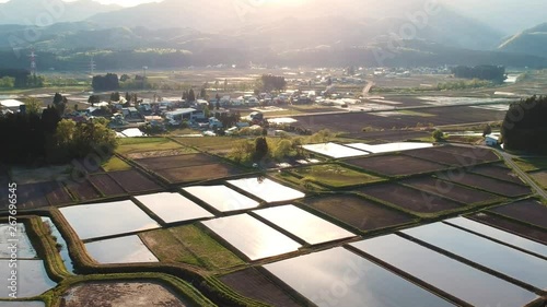 空撮　春の田園風景　水面に反射する太陽　日本　秋田県