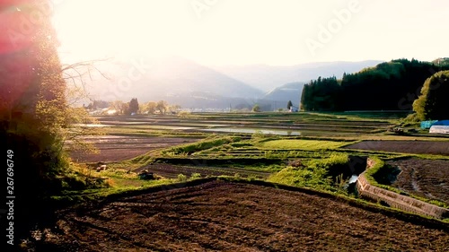 空撮　春の田園風景　水面に反射する太陽　日本　秋田県