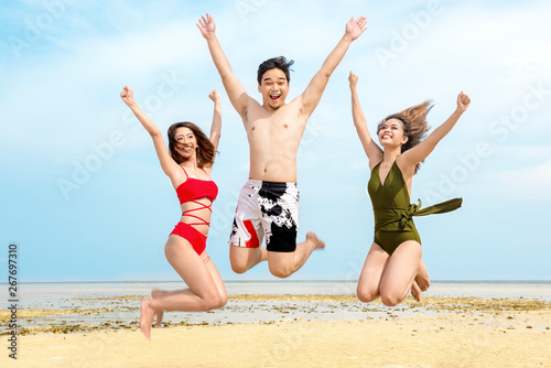 Group of asian friends having fun and jump together on the beach