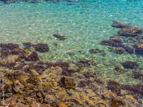 Crystal clear blue water and rocky shore