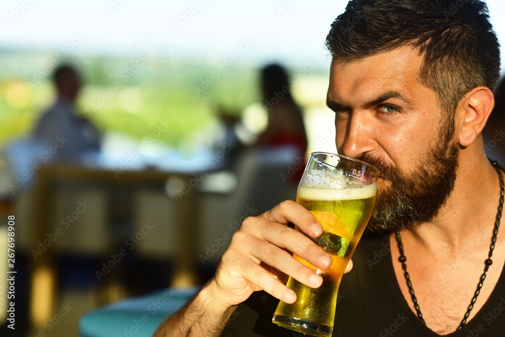 Brutal hipster bearded man sit at bar counter. Beer pubs and bars. Brutal hipster bearded man sit at bar counter. Beer pubs and bars.