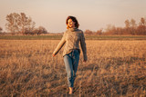 Portrait joyful young woman   brunette in brown knit sweater made of natural wool and jeans having fun, smile and enjoy day on field. stylish hipster woman.Outdoor atmospheric lifestyle photo