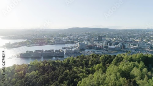4K aerial of the Oslo city line with a backdrop of downtown Oslo and Bjoervika, a popular tourist attraction with the Munch museum, Barcode and Soerenga pier, in evening with forward motion. photo