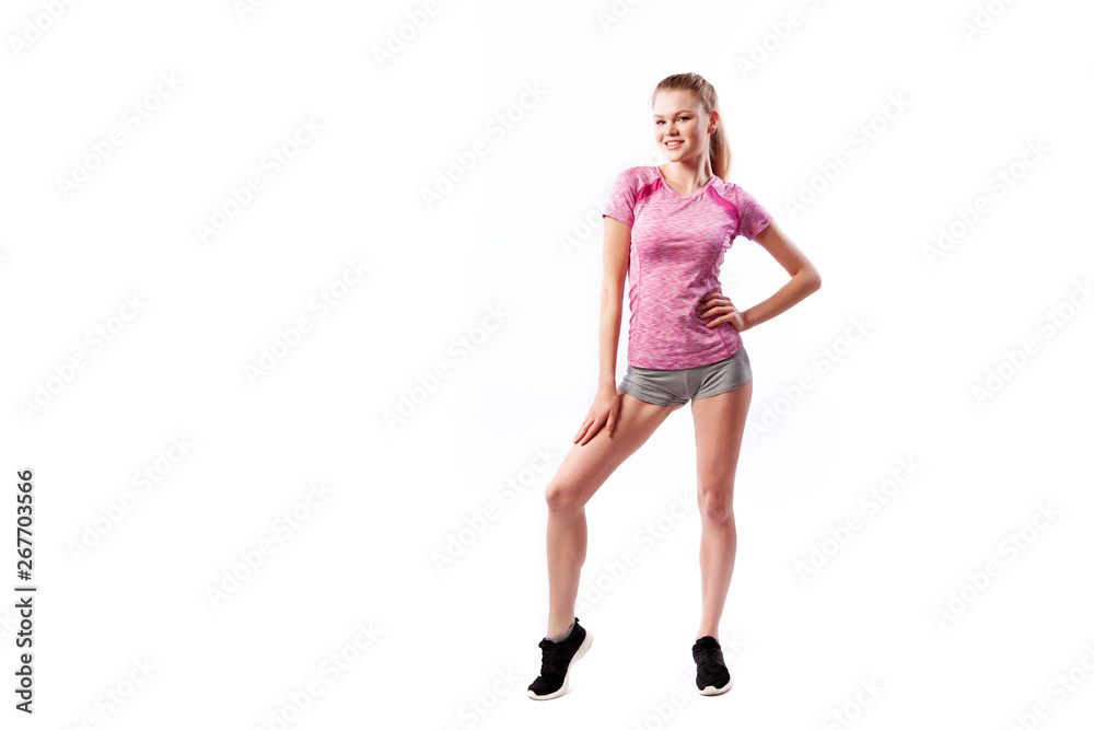 Sporty woman in t-shirt and shorts smilling and posing on white isolated background. Photo of muscular woman in sportswear on white background. Strength and motivation. Sporty woman in t-shirt and shorts smilling and posing on white isolated background. Photo of muscular woman in sportswear on white background. Strength and motivation.