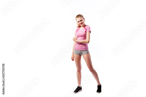 Sporty woman in t-shirt and shorts smilling and posing on white isolated background. Photo of muscular woman in sportswear on white background. Strength and motivation.