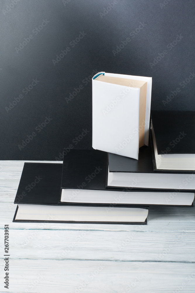 Open books on wooden table, black board background. Back to school. Education business concept.
