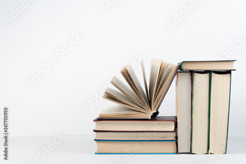 Book stack, hardback colorful books on wooden table, white background. Back to school. Copy space for text. Education business concept.