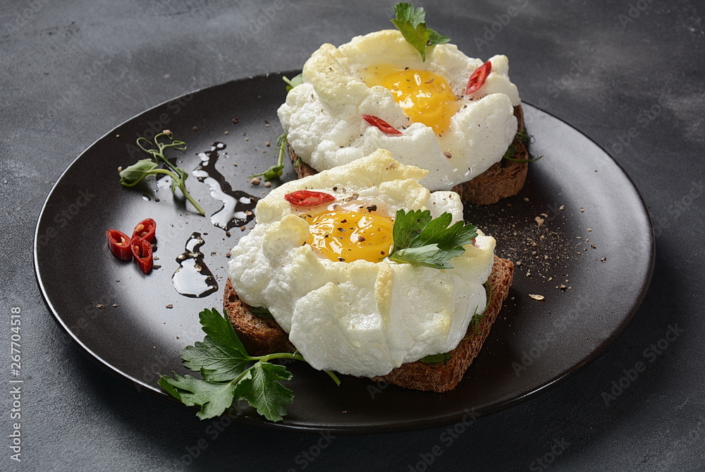 Delicate baked egg. Orsini eggs in the cloud. French breakfast.Cloud egg on toast Delicate baked egg. Orsini eggs in the cloud. French breakfast.Cloud egg on toast