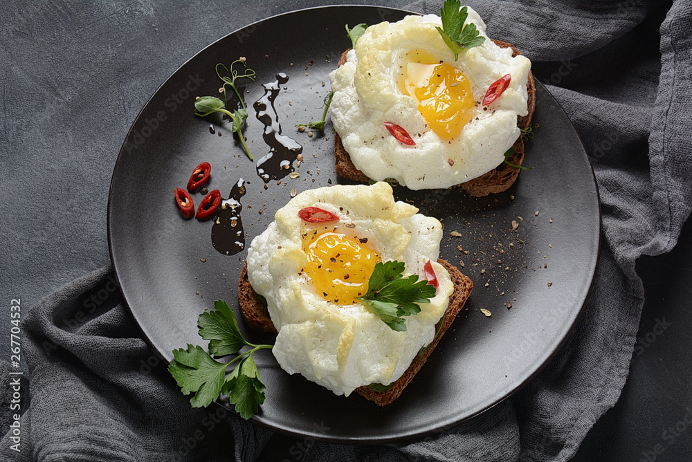 Delicate baked egg. Orsini eggs in the cloud. French breakfast.Cloud egg on toast Delicate baked egg. Orsini eggs in the cloud. French breakfast.Cloud egg on toast
