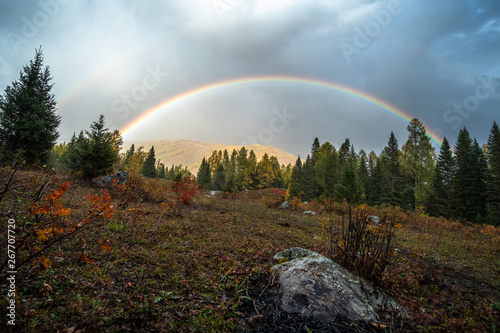 Rainbow sky with vibrant yellow autumn scene at Kanas lake, China