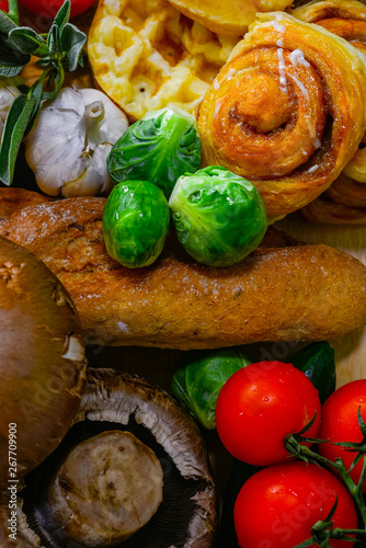 The arrangement of various breads and vegetables is still,cinnamao roll,garlic,Brussels Sprouts, tomato focus on Brussels sprouts photo