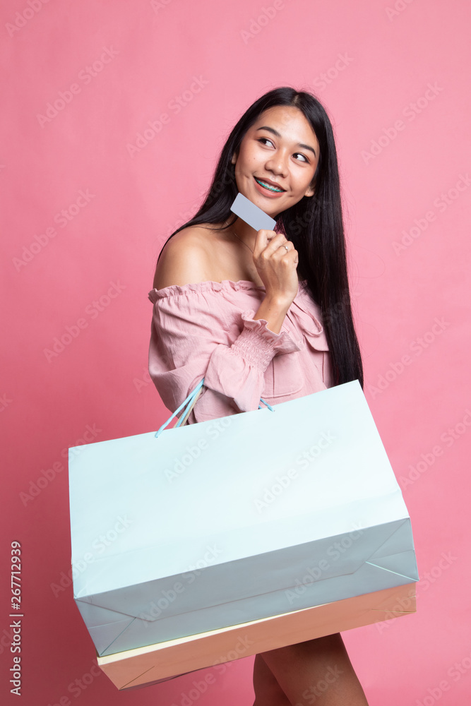 Young Asian woman with shopping bag and blank card. Young Asian woman with shopping bag and blank card.