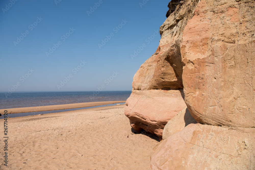 Limestone beach at the Baltic Sea, Latvia with beautiful sand pattern and vivid red and orange color - Veczemju Klintis