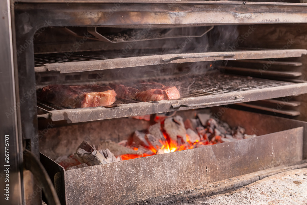 food, craft and delicious concept - cooking steak on a grill