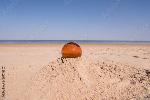 Glass sphere at the beach. Sunny summer day.