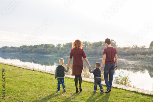 Parent, childhood and nature concept - Family playing with two sons by the water © satura_