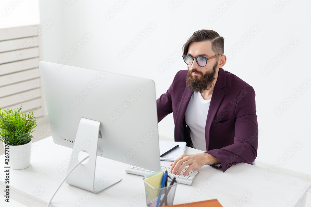 People and technology concept - Handsome man with beard working on at the computer