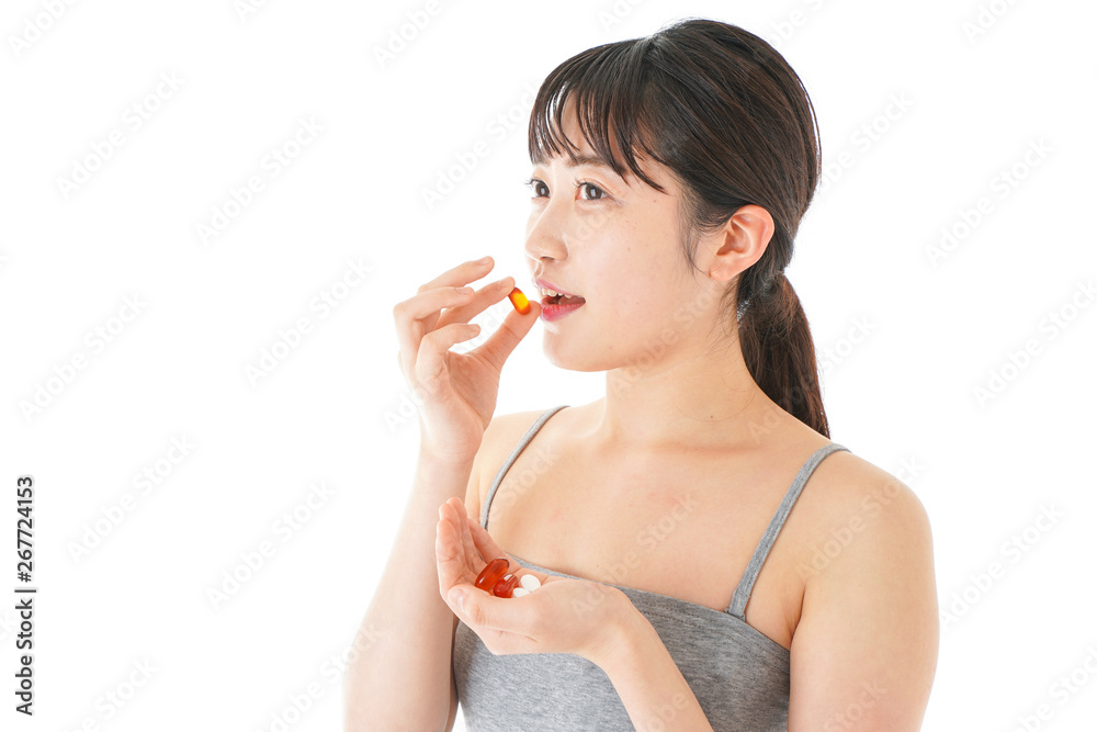 薬・サプリメントを服用する若い女性