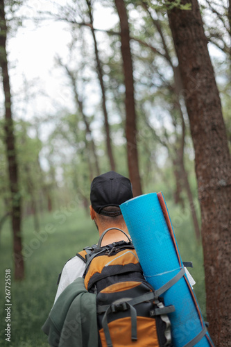 A young guy with a backpack in the cap, traveller in the woods, Hiking, Forest, Journey