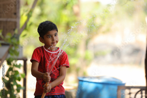 indian child playing with water tube