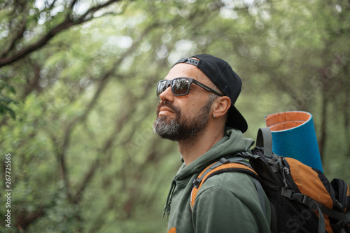 A young guy with a backpack in the cap, traveller in the woods, Hiking, Forest, Journey © Max