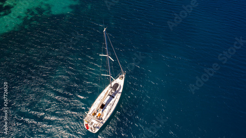 Aerial view of sea and yacht. Sailing ship in the middle of ocean, top view, summer background. Amazing view to Yacht sailing in open sea at sunny day © yusufozluk