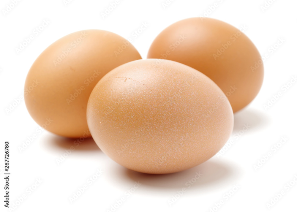 Wire whisk and brown eggs on white background Wire whisk and brown eggs on white background