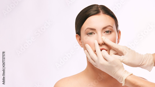 Female derma rejuvenate treatment. Doctor in gloves touch woman face. Cosmetology pretty portrait. Facial injection patient photo