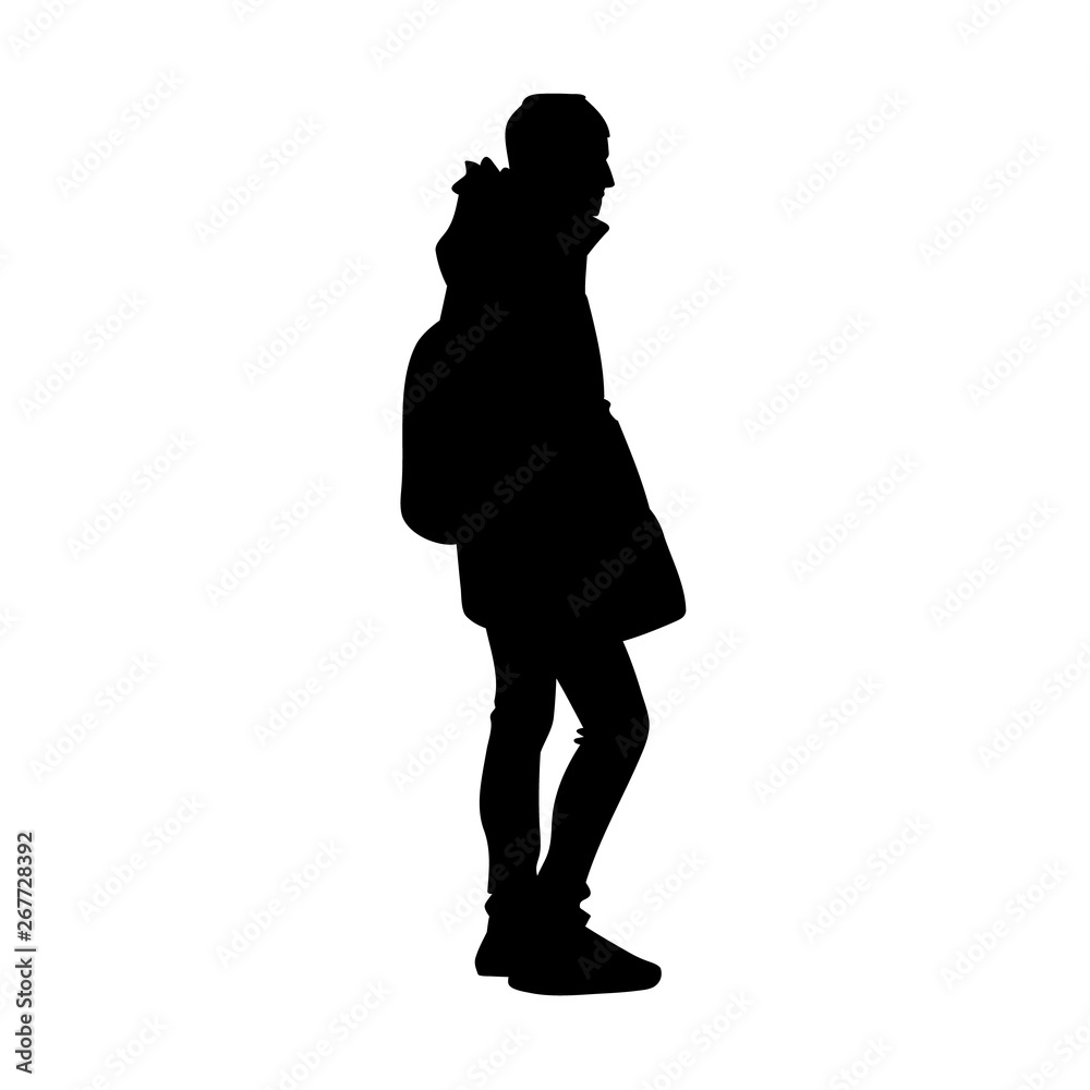 Young man in warm jacket, jeans and sneakers standing. Black silhouette isolated on white background. Side view. Monochrome vector illustration of young man with backpack. Concept