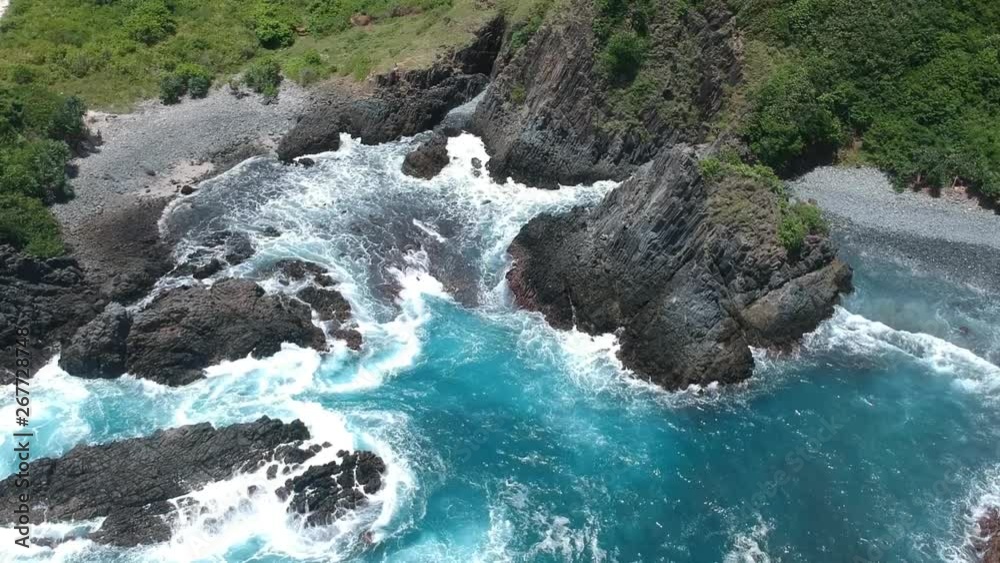 Slow motion shot of waves crashing into to the rocks in a remote beach in Lombok Indonesia. Slow motion shot of waves crashing into to the rocks in a remote beach in Lombok Indonesia.