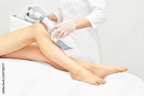 Laser ipl device in doctor hand. Woman body hair removal. Perfect epilator. Cosmetology leg technology photo