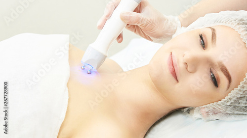 Light infrared therapy. Cosmetology head procedure. Beauty woman face. Cosmetic salon device. Facial skin rejuvenation