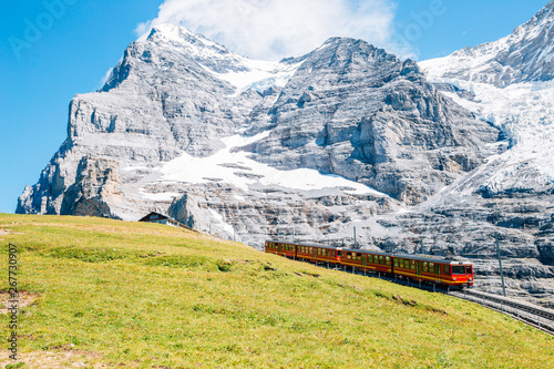 Jungfrau Eigergletscher snowy rocky mountain and red train in Switzerland photo