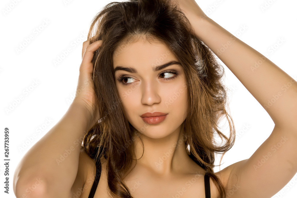 Naklejka premium Young woman with makeup posing on white background