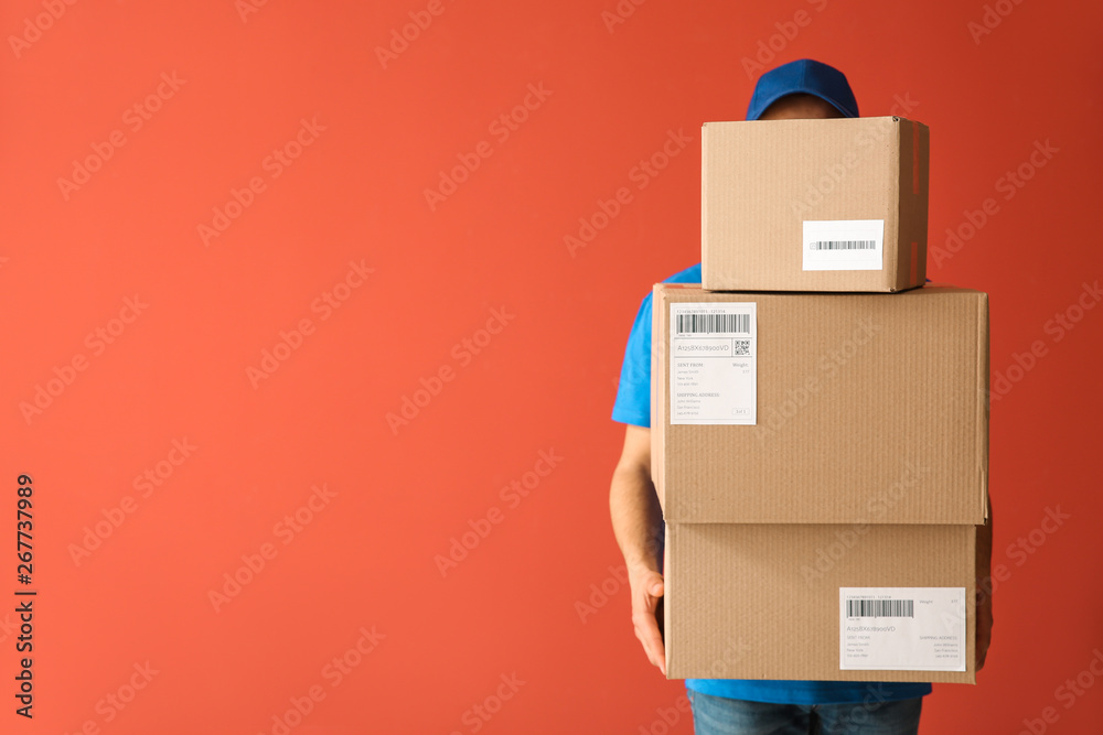 © Pixel-Shot - Delivery man with boxes on color background © Pixel-Shot - Delivery man with boxes on color background