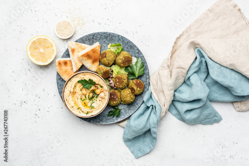 Falafel, hummus and pita bread. Arabian style appetizer. Healthy vegan and vegetarian food concept. Table top view, concrete background. photo