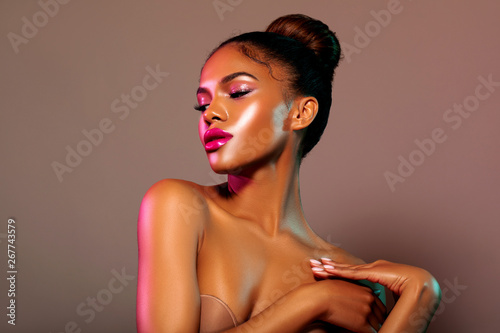 Beauty portrait fashion girl with color lighting filters. Beauty girl face close up. Closeup African  American woman with copy  space. Neon light blue and pink color. - image.    