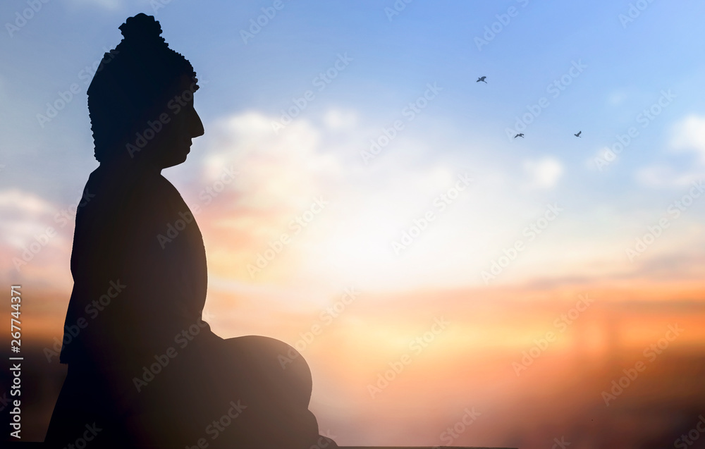 Day of Vesak concept: a statue of Buddha at sunset background Day of Vesak concept: a statue of Buddha at sunset background