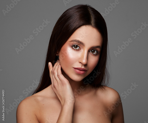 Beauty portrait of young woman touching heek
