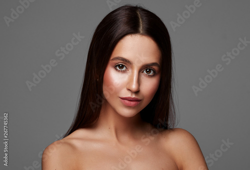 Beautiful woman with long hair and big brown eyes isolated on gray background