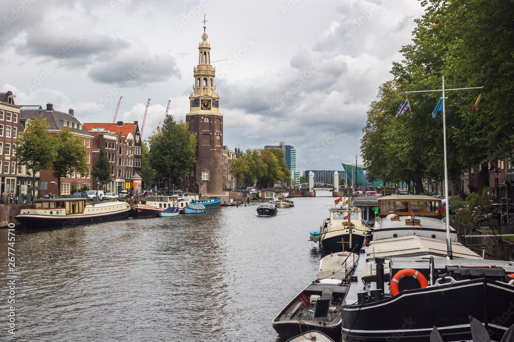 The Montelbaanstoren with some boats navigating on the canal