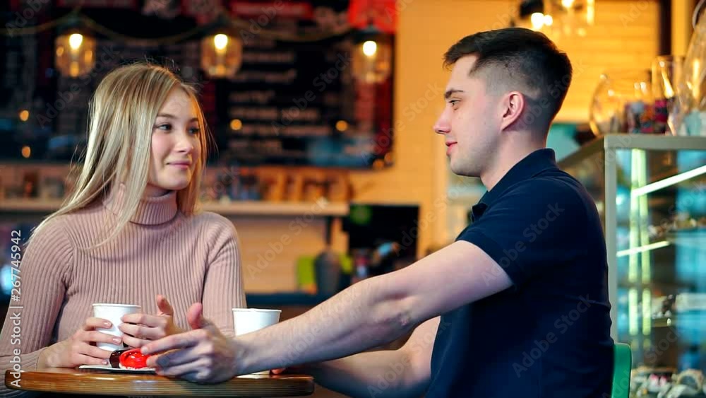 Happy Couple At The Coffee Shop. They are talking over a cup of coffee.