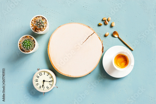 Mornind blue background with empty board, cup of coffee and alarm clock