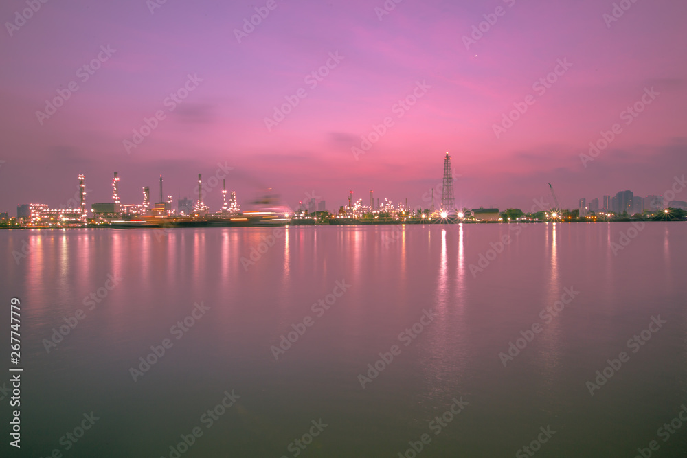 Fototapeta premium The blurred background of nature along the river, with views of the cargo ship, oil refinery, sunrise and beautiful sky in the morning