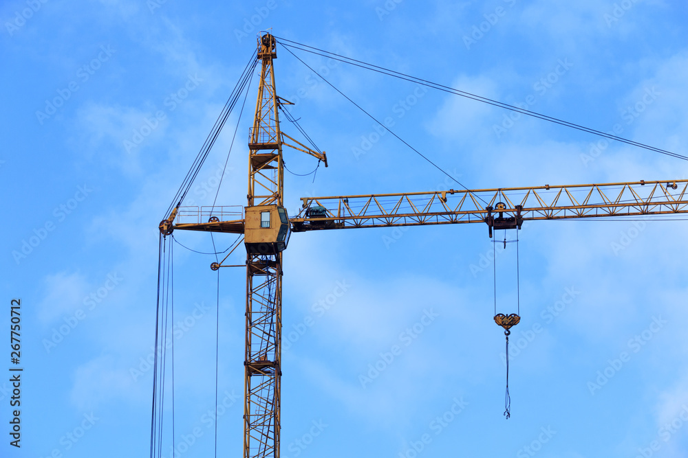 Construction crane against the blue sky background.